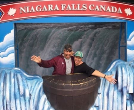 two people in front of a Niagara Falls Canada banner