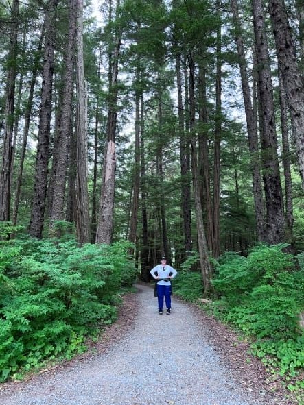 girl standing in Sitka National Forest in hiking pants