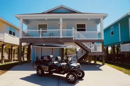 golf cart rental in front of two story home in Port Aransas