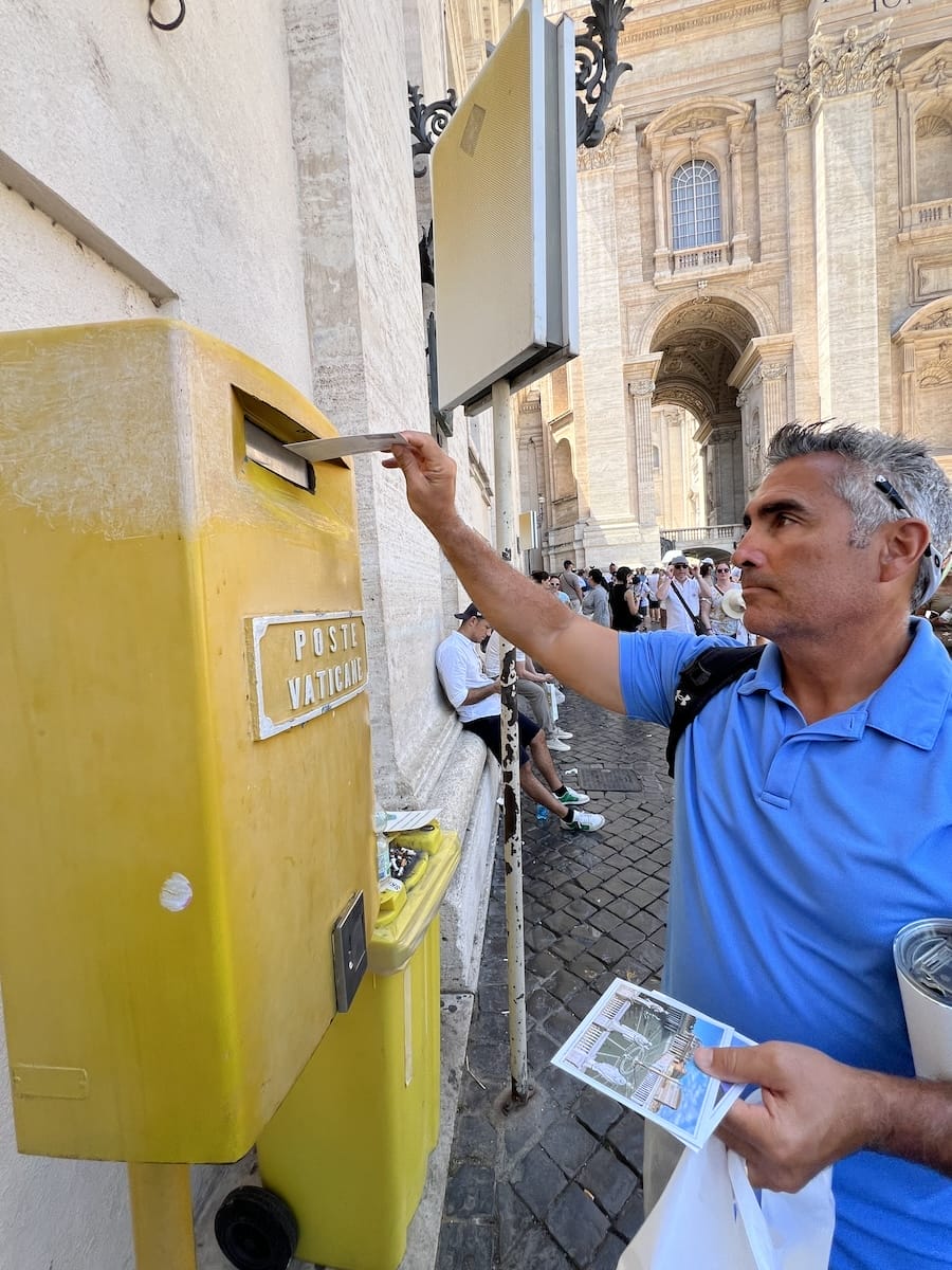 man mailing post card at Vatican mail slot