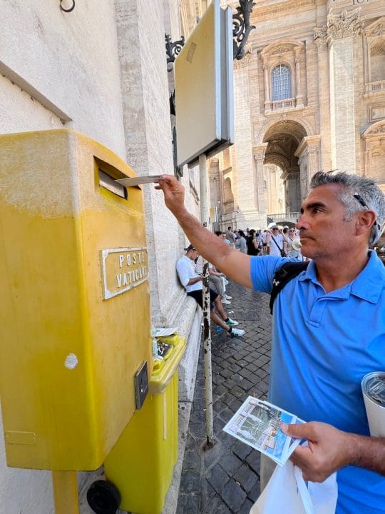 man mailing post card at Vatican mail slot